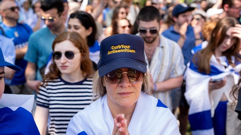 一名女性日前在华盛顿大学举行的反对校园反犹主义集会上，戴著一顶写著“遏制你的反犹主义”的帽子。（图取自法新社）