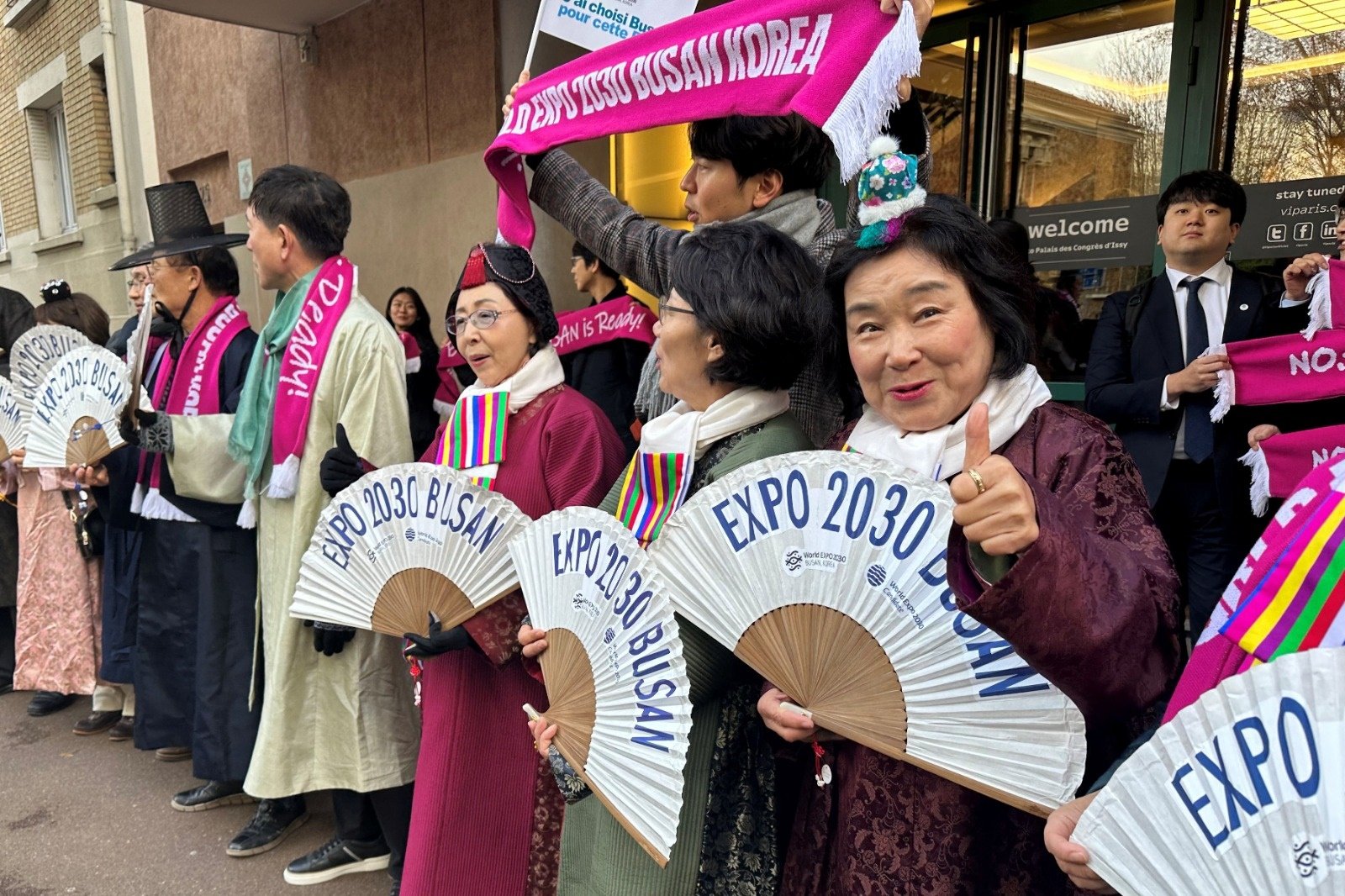在国际展览局于当地时间周二宣布2030年世博会主办权之前，韩国支持者聚集在巴黎郊区伊西莱穆利诺的议会宫外，为韩国釜山加油打气。（图取自路透社）