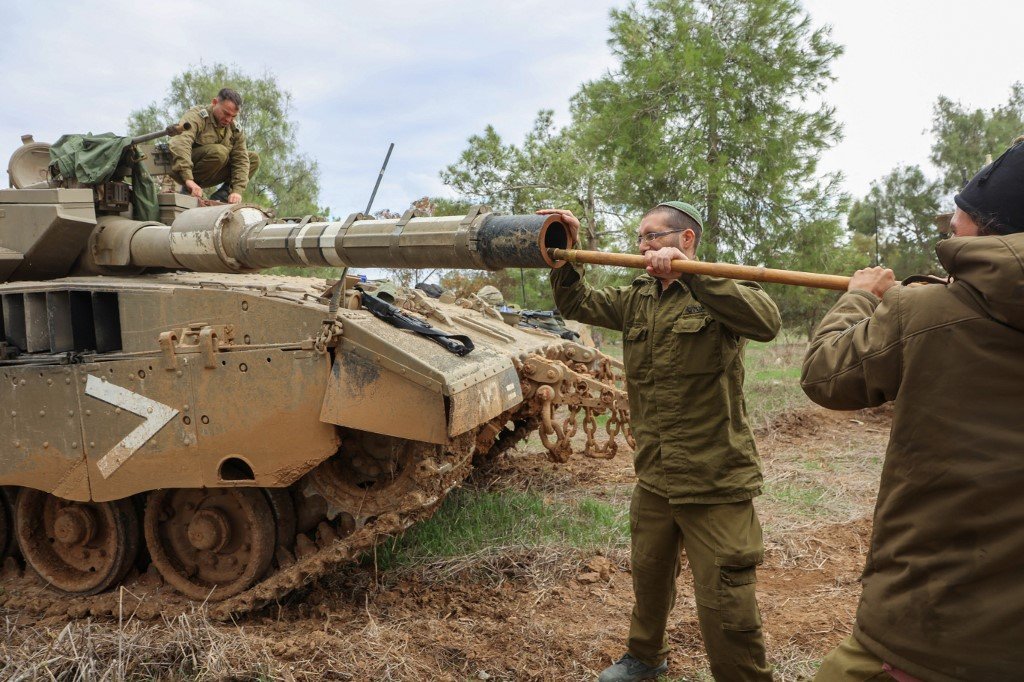 在以色列与哈马斯执行休战期间，以色列军队周二对部署在加沙地带南部边境的坦克进行维护。（图取自法新社）